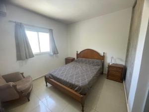 ein Schlafzimmer mit einem Bett und einem Stuhl und einem Fenster in der Unterkunft La Juanita in San Juan