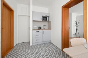 a kitchen with white cabinets and a microwave at Ubytování Dva v centru in Velké Meziříčí