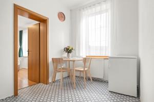 a kitchen with a table with two chairs and a refrigerator at Ubytování Dva v centru in Velké Meziříčí +7 photos