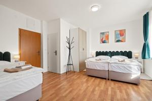 a white bedroom with two beds in it at Ubytování Dva v centru in Velké Meziříčí