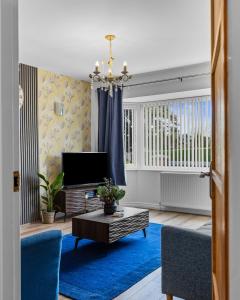 a living room with a tv and a blue rug at Greenview in Spinney Hill
