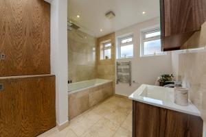 a bathroom with a bath tub and a sink at Berwick Soho Suites by Aureva Residences in London