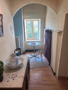 Una sala de estar con una mesa y una ventana. en Chambre Chez L'habitant, en Sermérieu