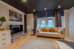 a living room with a couch and a tv at Berwick Soho Suites by Aureva Residences in London