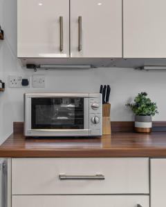 a microwave oven sitting on top of a kitchen counter at Greenview in Spinney Hill