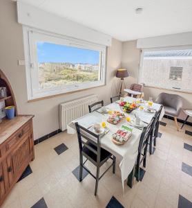 Un comedor con mesa y sillas y una ventana. en Marluis Mer - Apartment near dunes and beach, en Cucq