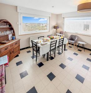 Una cocina y un comedor con mesa y sillas. en Marluis Mer - Apartment near dunes and beach, en Cucq
