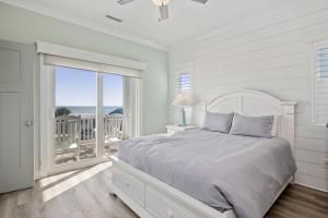 een witte slaapkamer met een bed en een balkon bij Wait N Sea by Oak Island Accommodations in Oak Island +190 foto's