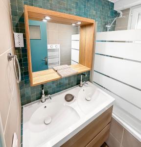 a bathroom with a white sink and a mirror at Marluis Mer - Apartment near dunes and beach in Cucq
