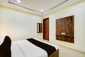 a bedroom with a white bed and a wooden wall at Hotel O Hotel R Pacific in Hyderabad