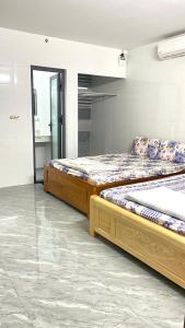 two twin beds in a room with a mirror at Nhà Nghỉ PHÚC THỊNH 