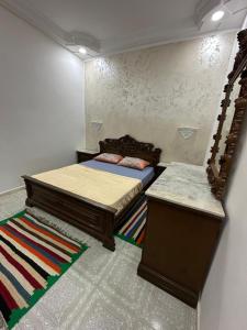 a bedroom with two beds and a rug at Dar Ben Othman in Tozeur