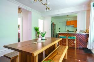 a dining room with a wooden table and bench at Jungle House Columbus Short North Downtown Free Parking - Steps to Convention Center & Nationwide Arena - 2BR Luxury Home - Sleeps 8 - Over 5,800 Five Star Stays in Columbus