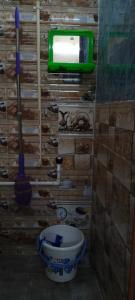 a bathroom with a toilet and a tv on the wall at F & N Stay in Tiruvannāmalai