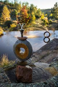a water fountain in front of a pond at Village in La Cumbrecita