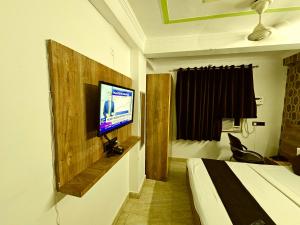a hotel room with a bed and a flat screen tv at Hotel Sunshine At Delhi Airport in Dwarka, New Delhi +31 photos