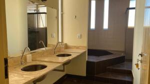 a bathroom with two sinks and a shower at Solar dos Costais in Uberaba +14 photos