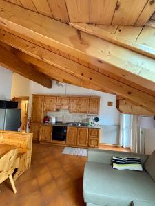 プレダッツォにあるAppartamento Genzianaのソファとキッチンのあるリビングルーム