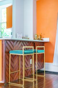 a kitchen with two stools in front of a counter at Jungle House Columbus Short North Downtown Free Parking - Steps to Convention Center & Nationwide Arena - 2BR Luxury Home - Sleeps 8 - Over 5,800 Five Star Stays in Columbus