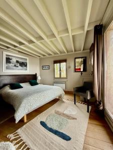 ein Schlafzimmer mit einem großen Bett mit Kassettendecke in der Unterkunft La sauvagine les pieds dans l'eau in Cricquebœuf