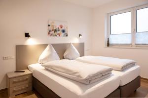 two beds in a room with white walls and a window at Gasthof Garni Knupfer in Ehingen