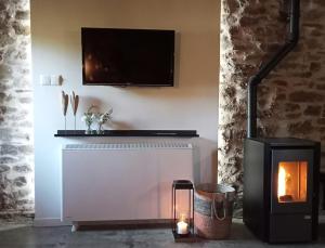 a living room with a fireplace and a tv at Casa Rural Arlanza 13 in Arlanza