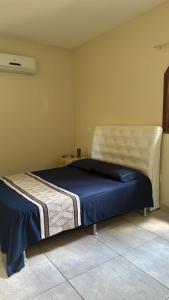 a bedroom with a large bed with a blue blanket at Pousada Spazio San jose in Saquarema