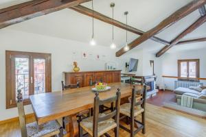 a dining room and living room with a wooden table and chairs at Little Cottage near Ferrari's City in Montale