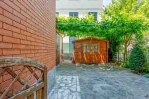 a brick wall with a wooden pergola at Little Cottage near Ferrari's City in Montale