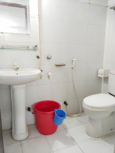 bagno con lavandino, servizi igienici e secchio di Hotel Rose International a Dhaka