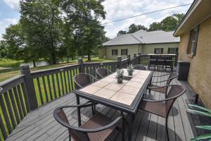 una terrazza in legno con tavolo e sedie. di Waterfront Home with Spacious Outdoor Deck Boat Slip a Northport