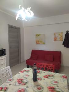 a living room with a red couch and a table at Casa Vacanze Falco in Agropoli