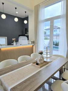 a dining room with a wooden table and chairs at Santara Pool Villa Udon in Udon Thani