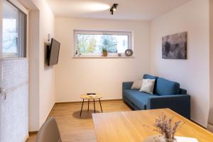 a living room with a blue couch and a table at Gasthof Garni Knupfer in Ehingen