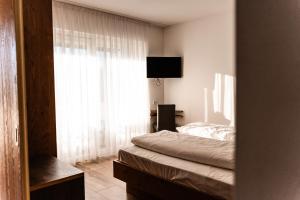 een slaapkamer met een bed en een groot raam bij Residence Tannhof in Caldaro +15 foto's