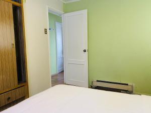 Un dormitorio con una cama y una puerta abierta. en Gran Via Hostel, en Punta Arenas