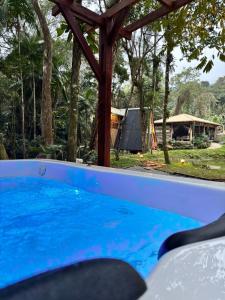 een dompelbad in een tuin met een pergola bij Recanto - Chalé Boa Vista in Jaraguá do Sul