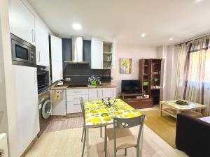 a kitchen and living room with a table and chairs at Loft BAINIS Peregrinos & Uso Turístico in A Guarda