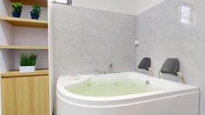 a bathroom with a bath tub with two chairs at Aryna Apartments in Goodlands