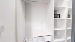 Armario blanco con estanterías blancas y microondas en Aryna Apartments, en Goodlands 37 fotos más