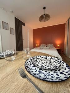 a room with a table with a plate and a bed at Charmant studio avec terrasse in Fécamp