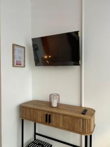 a wooden table with a tv on a wall at Charmant studio avec terrasse in Fécamp