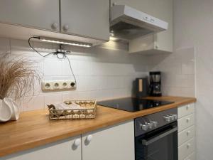 a kitchen with white cabinets and a counter top at Ferienwohnung Erdgeschoss in Fehmarn