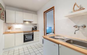 a kitchen with white cabinets and a sink at Ferienwohnung Erdgeschoss in Fehmarn +5 photos