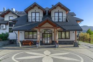a large house with a black roof at Pensjonat Perła Pienin in Grywałd
