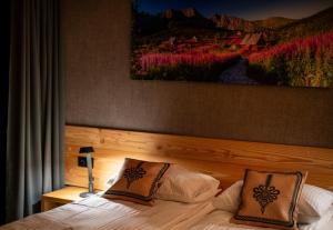 a bedroom with a bed with a painting on the wall at Janiołów Wierch 43 Jacuzzi i Sauna in Groń +92 photos