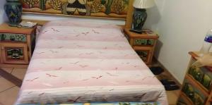 a bed in a room with red birds on it at Casa Vergel in Temixco +1 photo