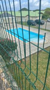 a swimming pool seen through a fence at Lovely 2 bedroom condo with pool in Marigot