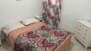a small bedroom with a bed with a colorful blanket at Lovely 2 bedroom condo with pool in Marigot