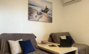 a living room with a table and a laptop on a chair at Summer house Kruce in Kruče